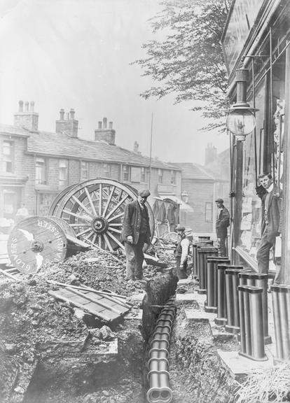 Works photographic negative of men laying ducting