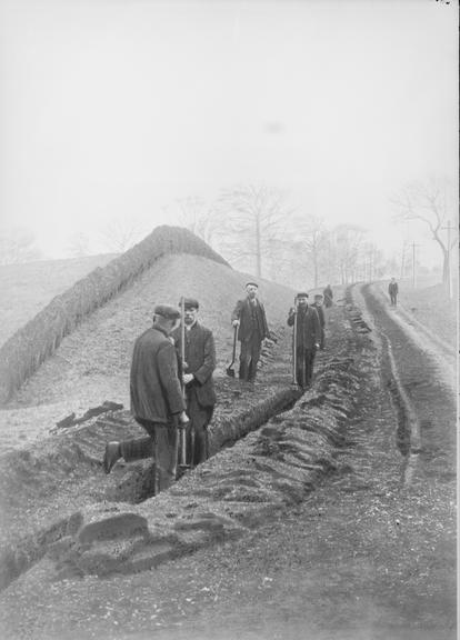 Works photographic negative of men filling-in trench