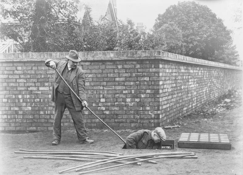 Works photographic negative of men working in manhole