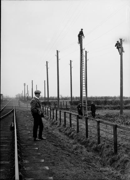 Works photographic negative of man by railway tracks, Ashington