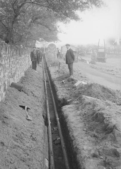 Works photographic negative of steel tubes laid in trench