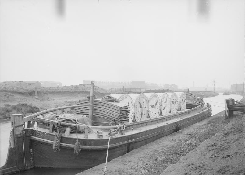 Works photographic negative of cable drums on barge