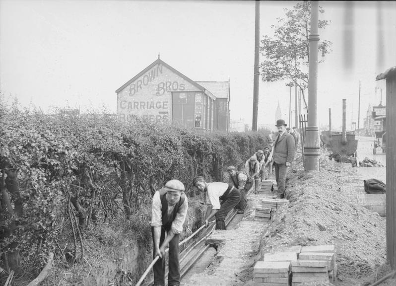 Works photographic negative of men laying cables, Shelford