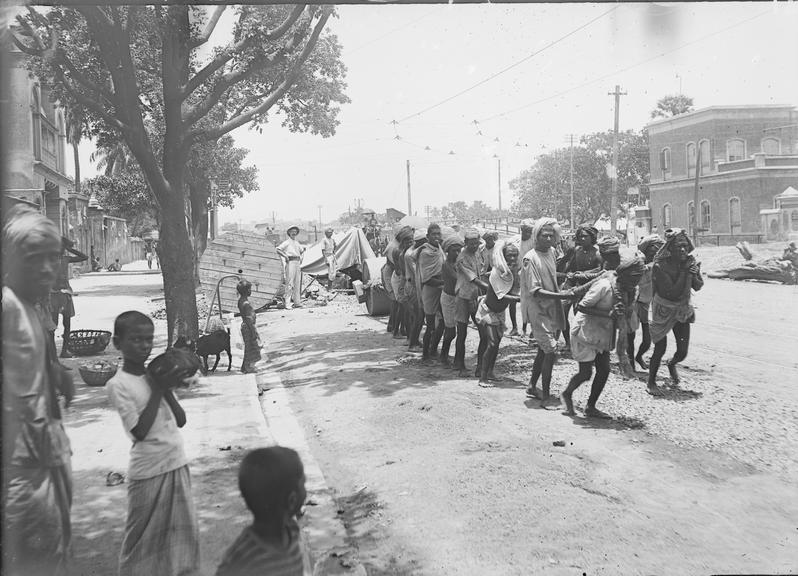 Works photographic negative of local men pulling heavy roller