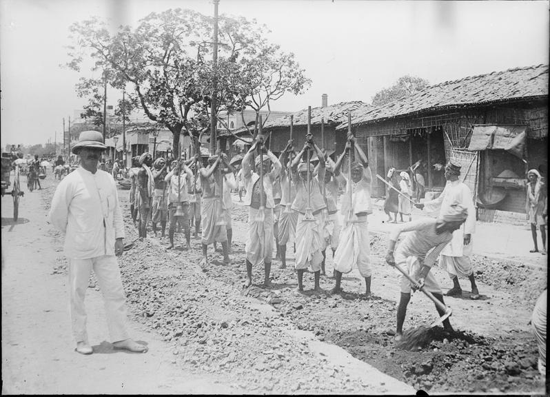 Works photographic negative of local men tamping roadway