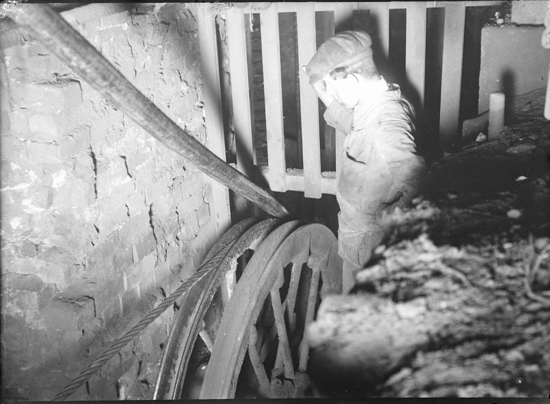 Works photographic negative of man observing cable