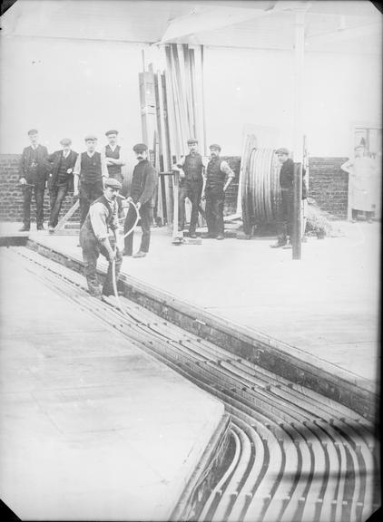 Works photographic negative of men laying cable, Wray Mill