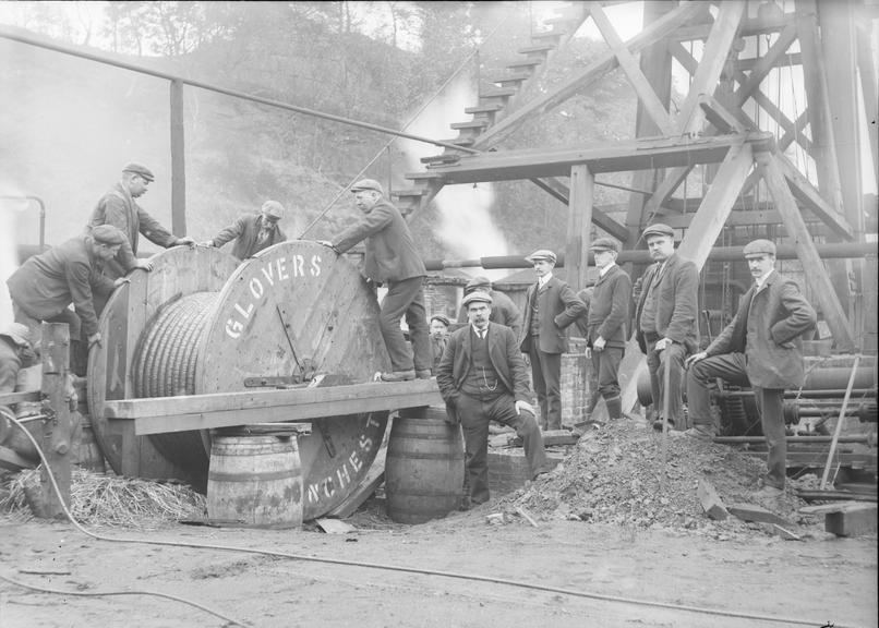 Works photographic negative of men feeding cable off drum