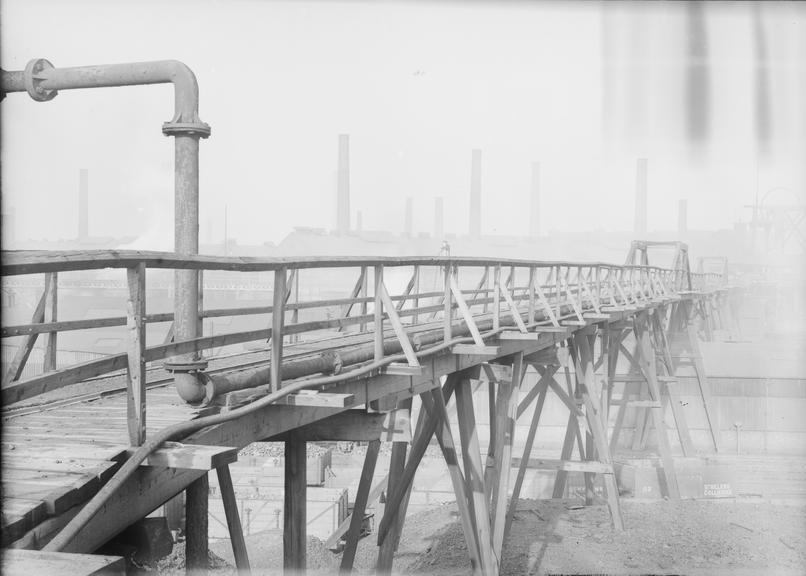 Works photographic negative of cable run across pipe gantry