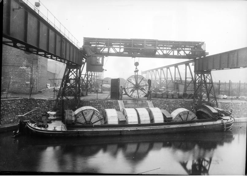 Works photographic negative of cable drum being lowered into