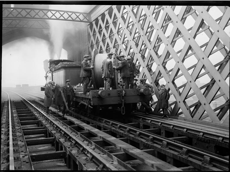 Works photographic negative of men with cable drum on railway