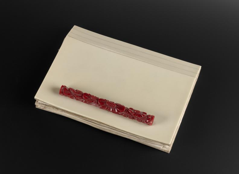 Hand bag of cream urea formaldehyde with red moulded handle