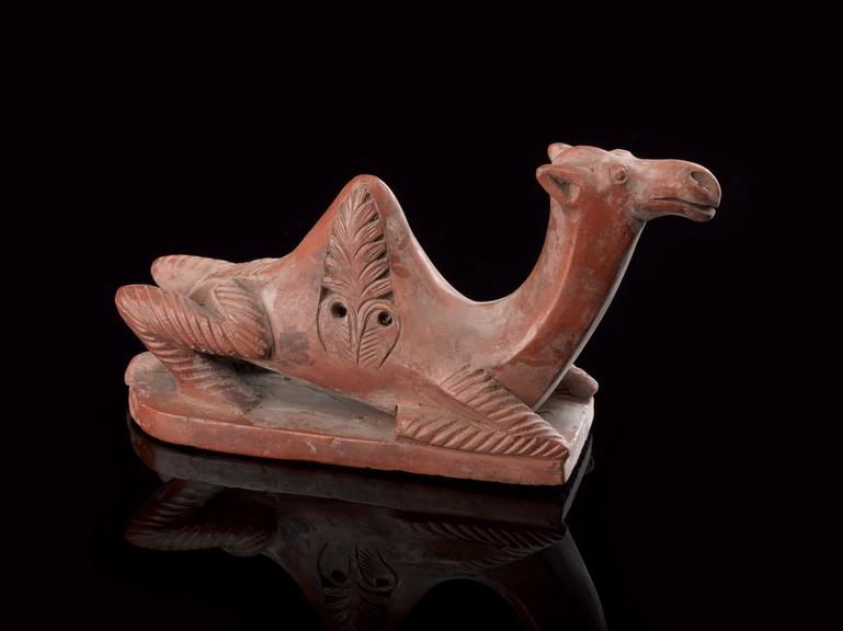 Red earthenware foot-scraper in the form of a recumbent camel