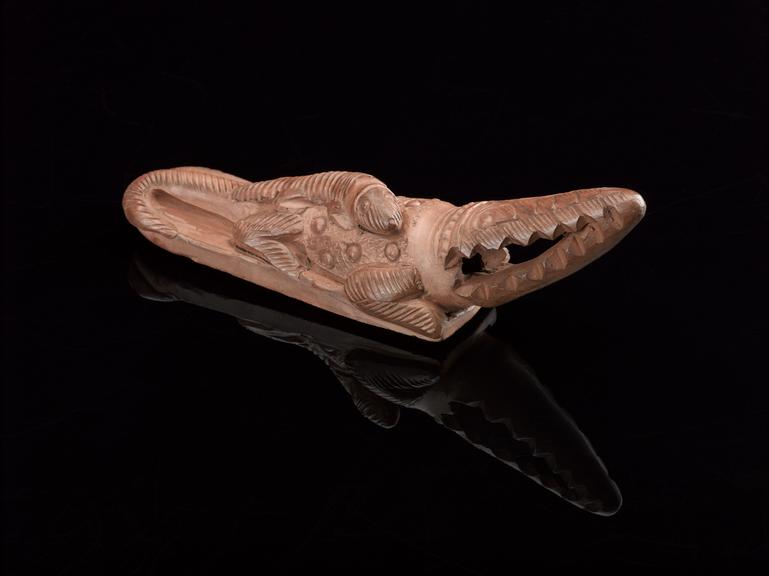 Brown earthenware foot scraper in the form of a crocodile with