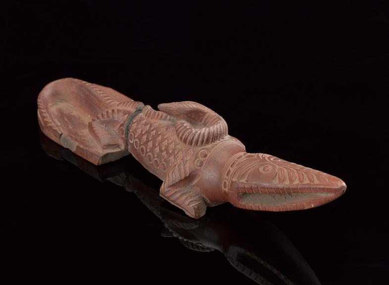 Red earthware foot-scraper in the form of a crocodile with skin