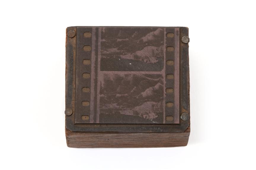 A printing block with a surface image of a section of film reel