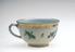 Small porcelain teacup with painted flowers and gilt decoration