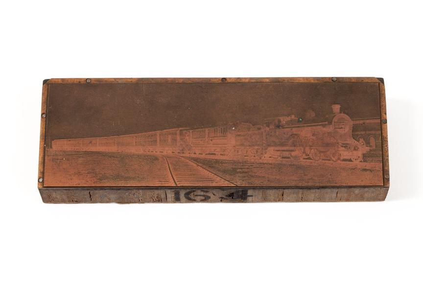 A printing block with a surface image of a locomotive hauling a