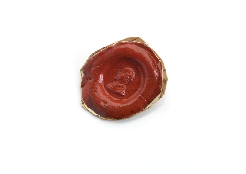 Oval seal with red stamp showing Shakespeare's head