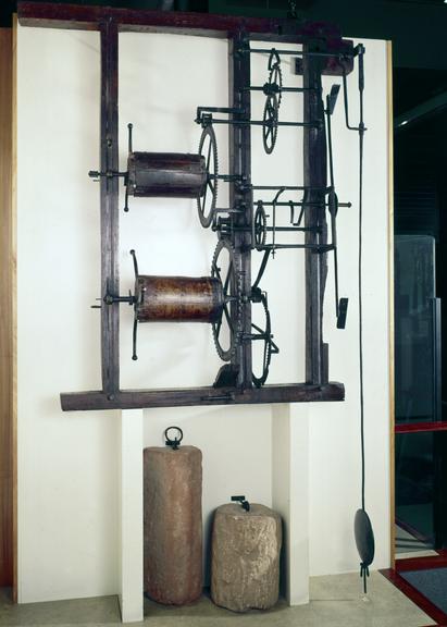 Iron turret clock in wooden frame, with pendulum rod