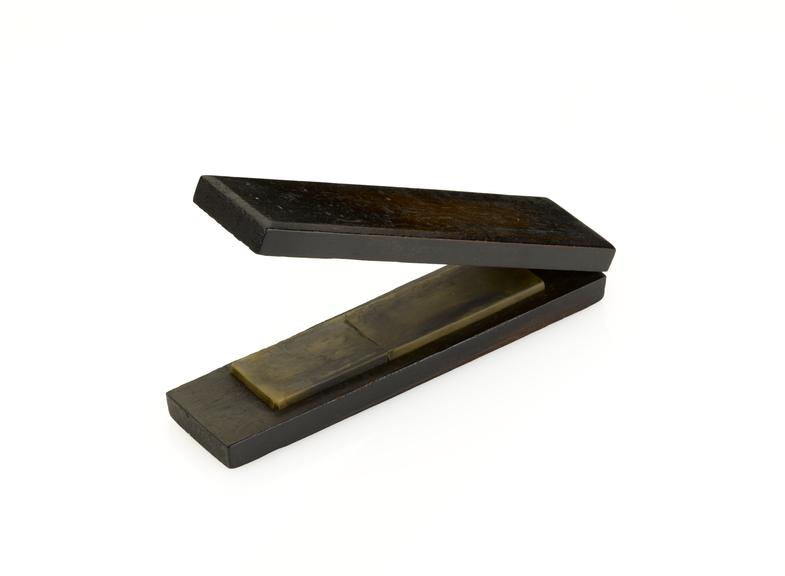 Watchmaker's tool sharpening stone in case.