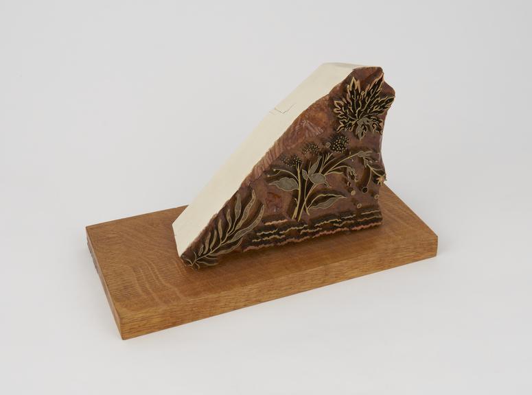 Silk printing block mounted on a wooden stand.