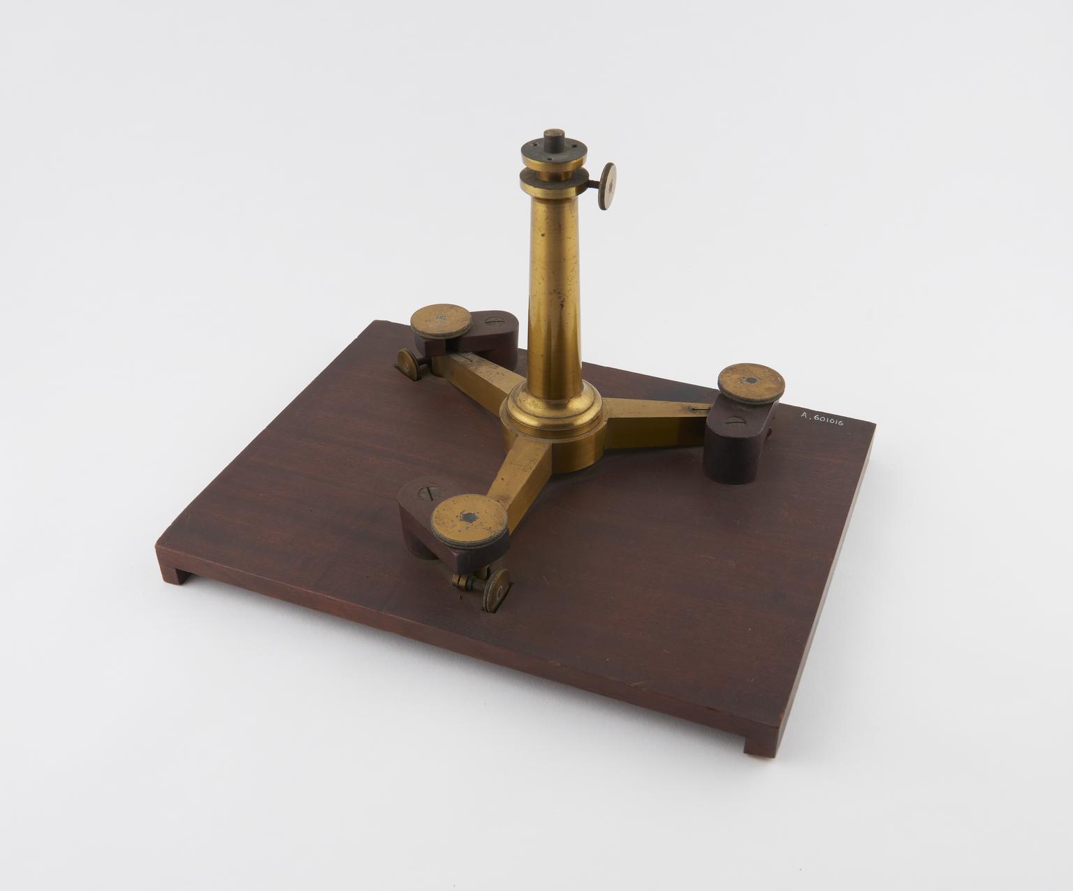 Brass pillar and tripod foot with levelling screws on baseboard ...