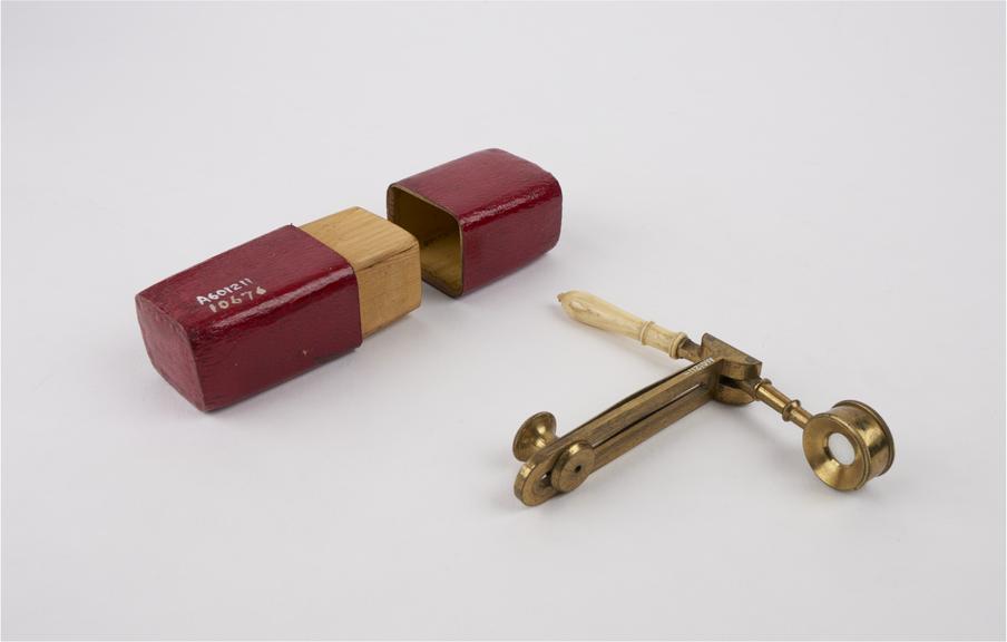 Folding hand microscope, in deal case covered with red leather