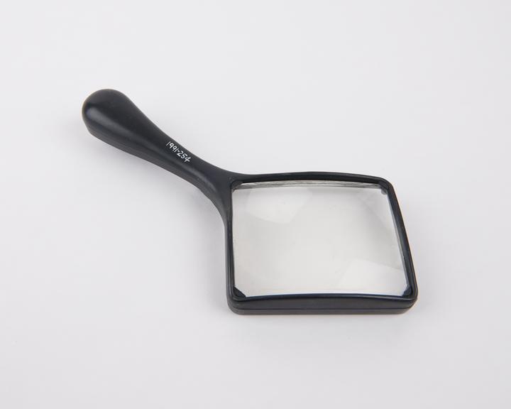 A rectangular aspheric magnifying glass (x2) with handle, by C