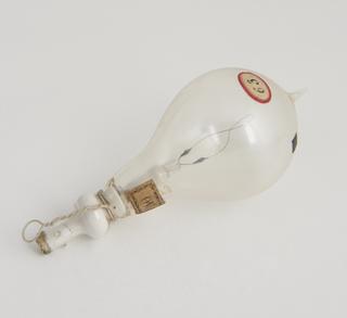 One of eighty-six early incandescent lamps.  "Twisted arch" filament.  Bulky cement joint to lead in