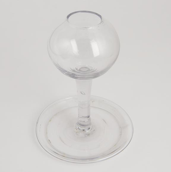 One of pair of early glass lamps with plain globular bowls on