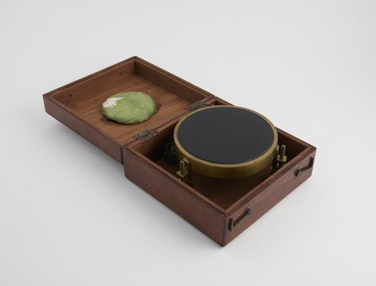 Artificial horizon of black glass, circular, in mahogany case