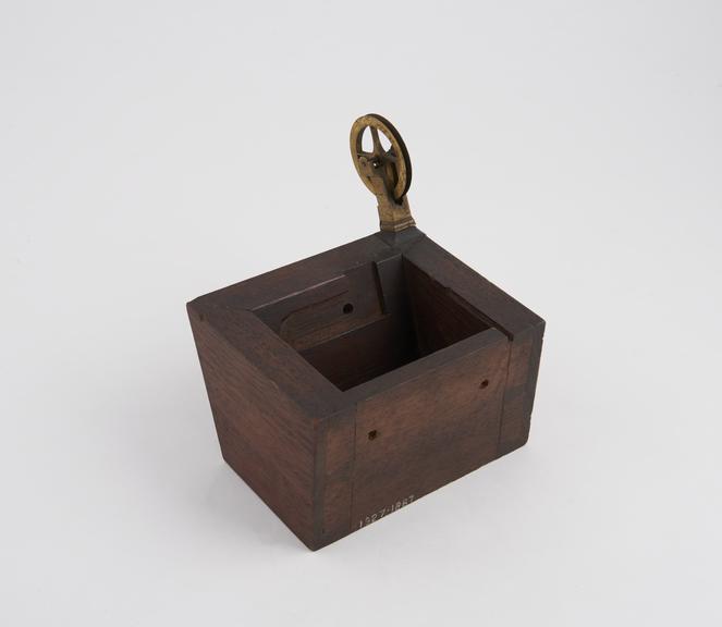 Tapering open ended box with bracket mounted pulley wheel