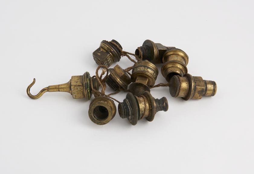 Nine brass end plugs, (one with hook and two with screwed caps)