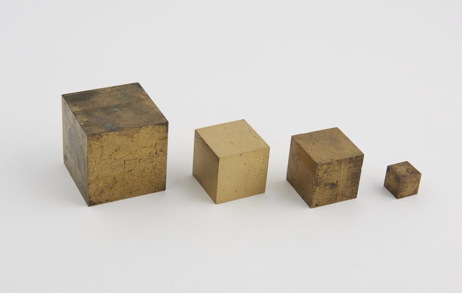 Four solid brass cubes