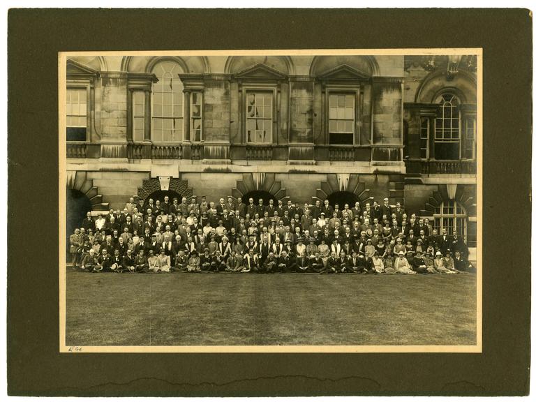 A mounted photographic print of a large group of people in