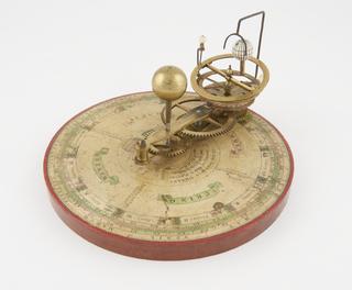 Simple portable orrery with brass gearwork and paper scale showing the Sun