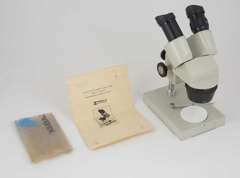 Stereoscopic microscope, model SKT, with cover, by Meiji