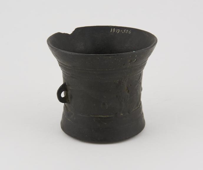 Bronze mortar with one handle, crudely cast with a broken rim