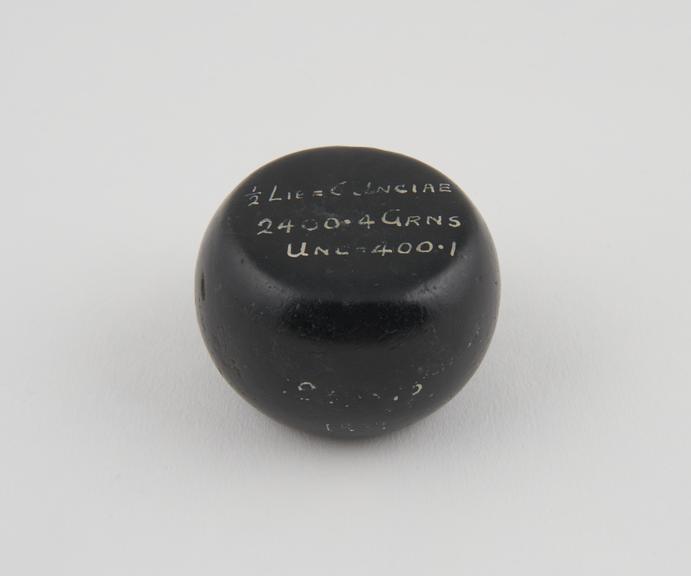 One of 15 Roman weights, cheese-shaped, polished black basalt