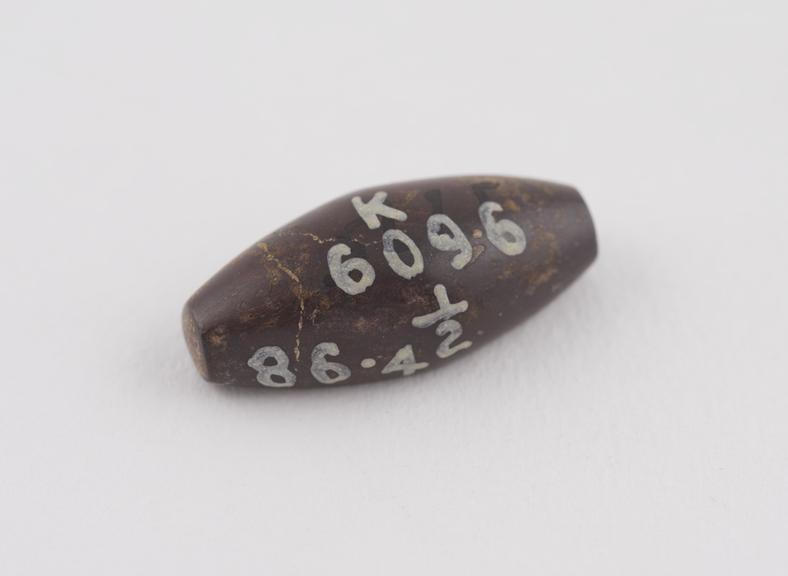 One of  2 brown haematite Syrian weights, barrel shaped