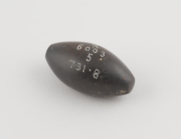 One of 9 black haematite Syrian weights, barrel shaped