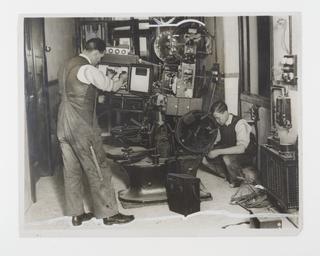 A photograph showing a sound projector being installed