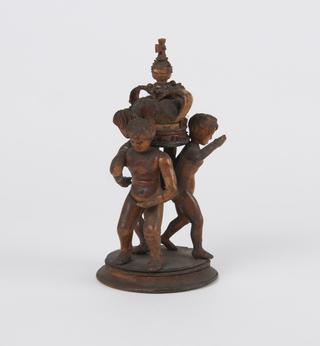 Wooden carving, of three children supporting a crown and a small component