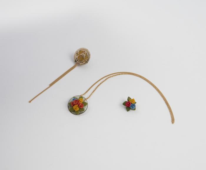 Two necklaces and an ear clasp made from coloured breadcrumbs