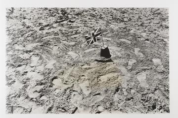 Photograph of footprints on sand with Union Jack flag