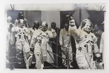 Photograph of Neil Armstrong leading the team to a vehicle taking them to the spaceship