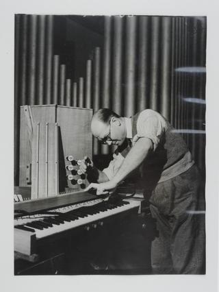 Photograph of a man constructing a church organ
