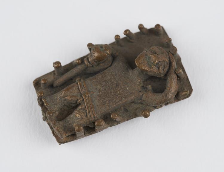 One of 84 Ashanti  brass weights in the form of a man lying on