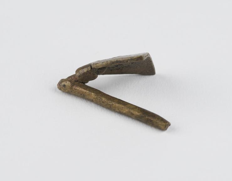 One of 84 Ashanti  brass weights in the form of a  drag hoe.